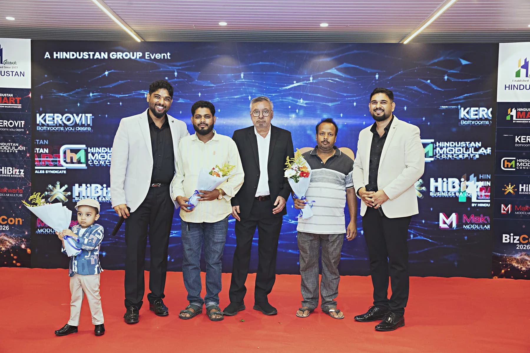 Guests receiving bouquets on stage during the HiBizz launch event in Goa