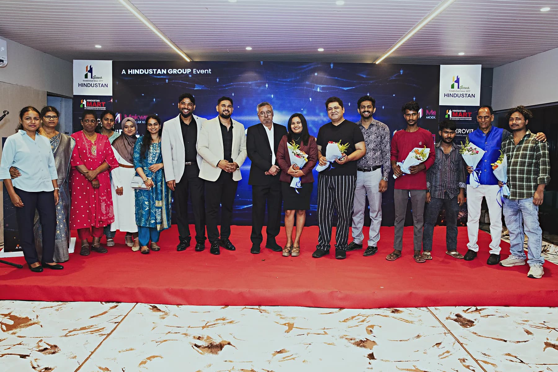Group photograph of hosts and guests on the red carpet at the HiBizz launch in Goa